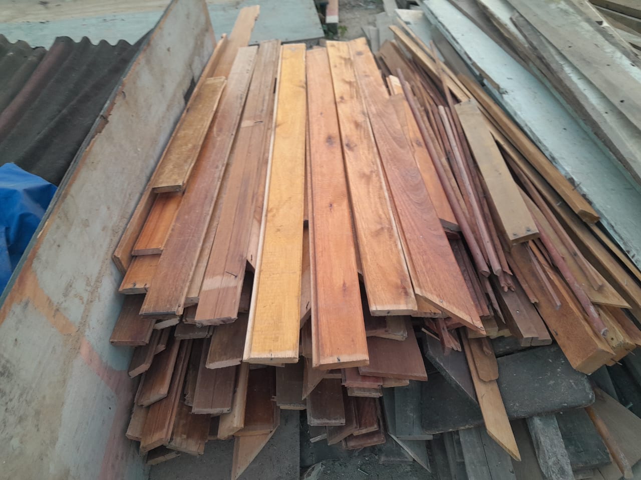 Pilha de tábuas e ripas de madeira reutilizada de diversos tamanhos, mostrando a variedade do estoque disponível para venda.